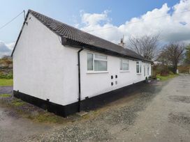 A side view of a house with windows and door at Y Byngalo in Trearddur Bay