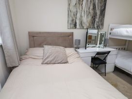 A bedroom with a bed and desk at Y Byngalo in Trearddur Bay