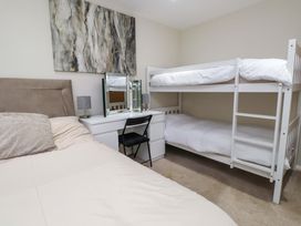 A bedroom with a bunk bed and a desk at Y Byngalo in Trearddur Bay