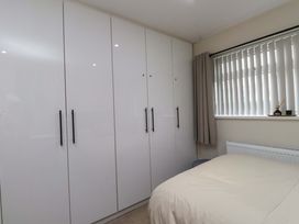 A bedroom with a wardrobe and bed at Y Byngalo Trearddur Bay