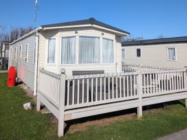 A static caravan with a deck and windows at 104 Lido Beach in Prestatyn