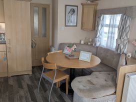 A dining area with a round table and chairs at 104 Lido Beach in Prestatyn