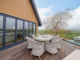 An outdoor patio with a table and chairs at Swing Bridge Cottage