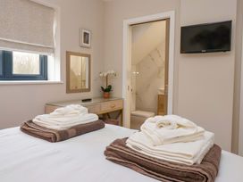 A bedroom with towels on the bed at Swing Bridge Cottage