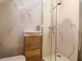 A bathroom with a shower and sink at Swing Bridge Cottage