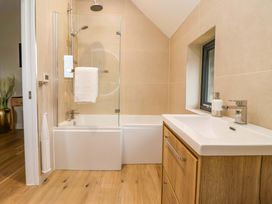 A bathroom with a bathtub and sink at Swing Bridge Cottage