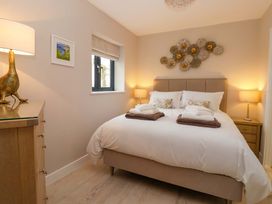 A bedroom with a bed and lamps at Swing Bridge Cottage