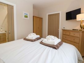 A bedroom with towels on the bed at Swing Bridge Cottage