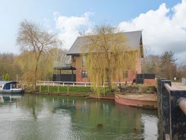 A house by the water with a boat at Swing Bridge Cottage in 