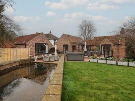 An outdoor area with houses and patio furniture at Mill Race Cottage in Driffield