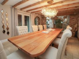 A dining room with a wooden table and chandelier at Mill Race Cottage in Driffield