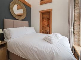 A bedroom with a bed, towels on it and a mirror at Mill Race Cottage in Driffield