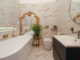 A bathroom with a bathtub, sink, and toilet at Mill Race Cottage in Driffield