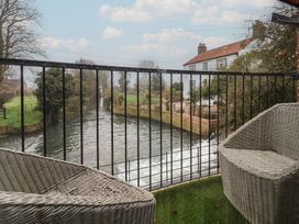 An outdoor space with river view and chairs at Mill Race Cottage in Driffield