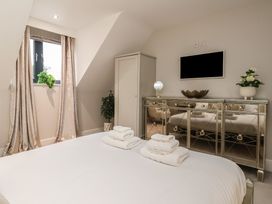 A bedroom with a bed and towels at Mill Race Cottage in Driffield