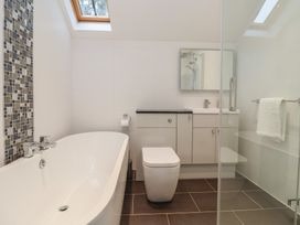 A bathroom with a bathtub and shower at Mill Race Cottage in Driffield