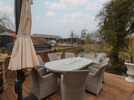 An outdoor dining area with a table and chairs at Mill Race Cottage in Driffield