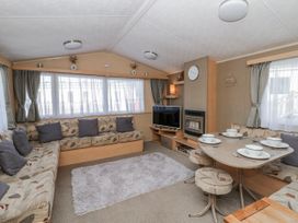 A living room with a sofa and dining table at Ger Y Mor in New Quay