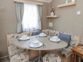 A dining area with a round table and seating at Ger Y Mor in New Quay