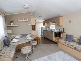 A living room with a dining table and kitchen area at Ger Y Mor in New Quay