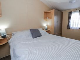 A bedroom with a bed and bedside lamps at Ger Y Mor in New Quay