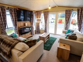 A living room with a sofa and a television at 108 Fox Burrow Hang in Great Yarmouth