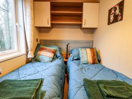 A bedroom with two beds and shelves at 108 Fox Burrow Hang in Great Yarmouth