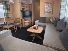 A living room with a sofa and television at 18 Fallows Fall in Leven