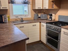 A kitchen with cabinets, appliances and countertop at 18 Fallows Fall in Leven