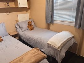 A bedroom with two beds and a teddy bear at 18 Fallows Fall in Leven