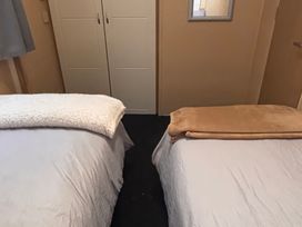 A bedroom with two beds and a wardrobe at 18 Fallows Fall in Leven