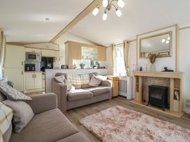 A living room with a sofa and fireplace at 2 bed Caravan in Stowmarket