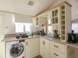 A kitchen with a washing machine and sink at 2 bed Caravan Stowmarket