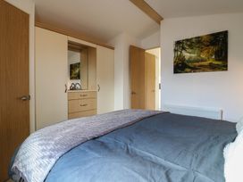 A bedroom with a bed and wardrobe at 2 bed Caravan Stowmarket