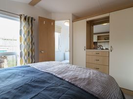 A bedroom with a bed and wardrobe at 2 bed Caravan Stowmarket