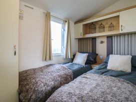 A bedroom with two single beds and a window at 2 bed Caravan Stowmarket