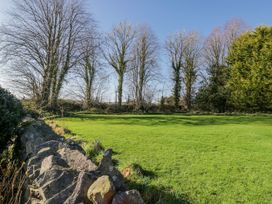 A garden with trees and a stone wall at Linden Lea in Grange-Over-Sands