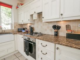 A kitchen with a sink and gas stove at Linden Lea Field Broughton near Cartmel