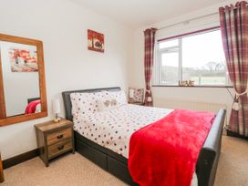 A bedroom with a bed and a mirror at Linden Lea Field Broughton near Cartmel
