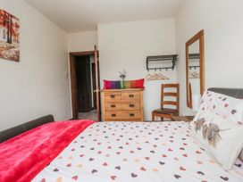 A bedroom with a bed and dresser at Linden Lea in Field Broughton near Cartmel