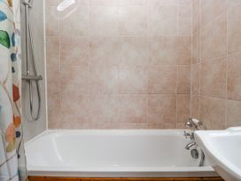 A bathroom with a bath tub and shower at Linden Lea in Field Broughton near Cartmel