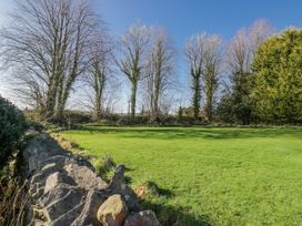 A garden with trees and a stone wall at Linden Lea in Field Broughton near Cartmel