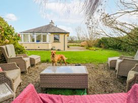 A garden with outdoor seating and a dog at Linden Lea Field Broughton near Cartmel