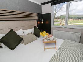 A bedroom with a bed and a tray of food at Daverneithon 4 near Llandrindod Wells