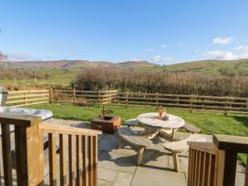 An outdoor seating area with a hot tub and fire pit at Daverneithon 4 near Llandrindod Wells