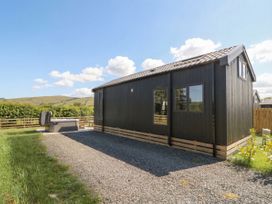 An outdoor area with a hot tub beside a building at Daverneithon 4 near Llandrindod Wells