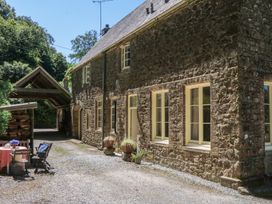 A stone house with outdoor furniture at Lukesland Wing in Ivybridge