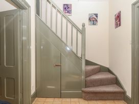 A staircase with photographs on wall at Lukesland Wing Ivybridge