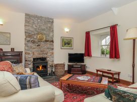 A living room with a fireplace and television at Lukesland Wing in Ivybridge