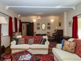 A living room with sofas and a piano at Lukesland Wing in Ivybridge